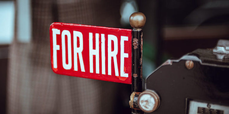 sign saying for hire word in a red background