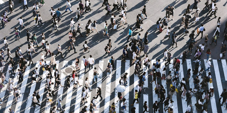 many people walking across pedestrian lane