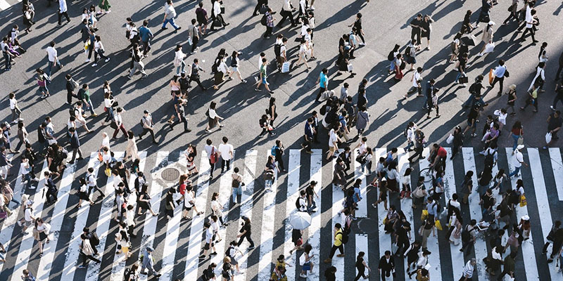 many people walking across pedestrian lane