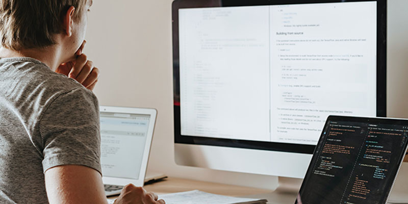 Man reviewing codes on monitors