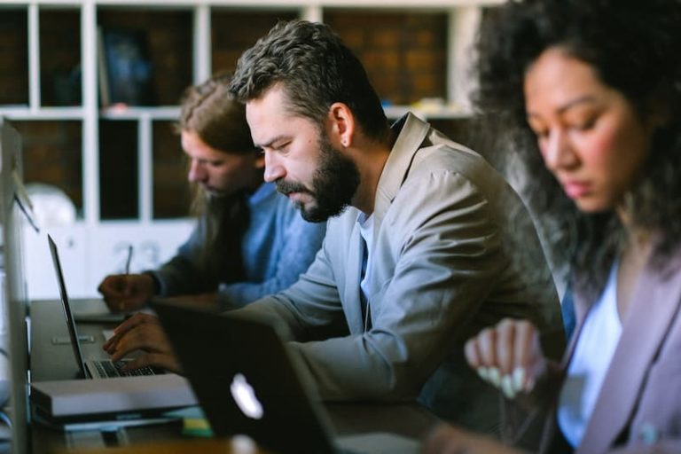 employees working on their laptops Feature Image For: How to Integrate Corporate Language Training for Employees