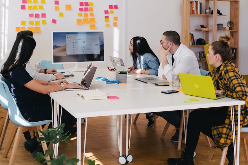 a team looking through a project Feature Image For: How to Write Job Ads for Startups (with Templates)
