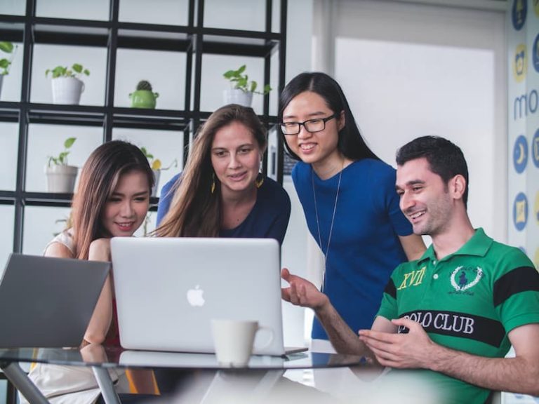 people smiling while looking at the laptop Feature Image For: Cara Merekrut Karyawan yang Efektif dan Efisien
